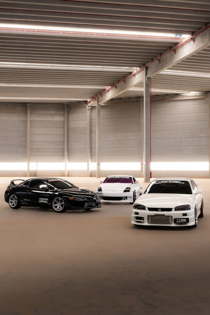 Three high-performance sports cars parked in a sleek, modern indoor garage.