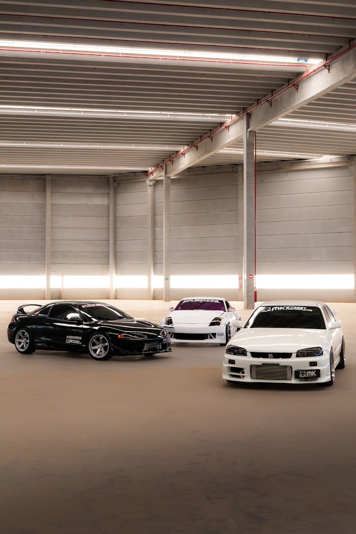 Three high-performance sports cars parked in a sleek, modern indoor garage.